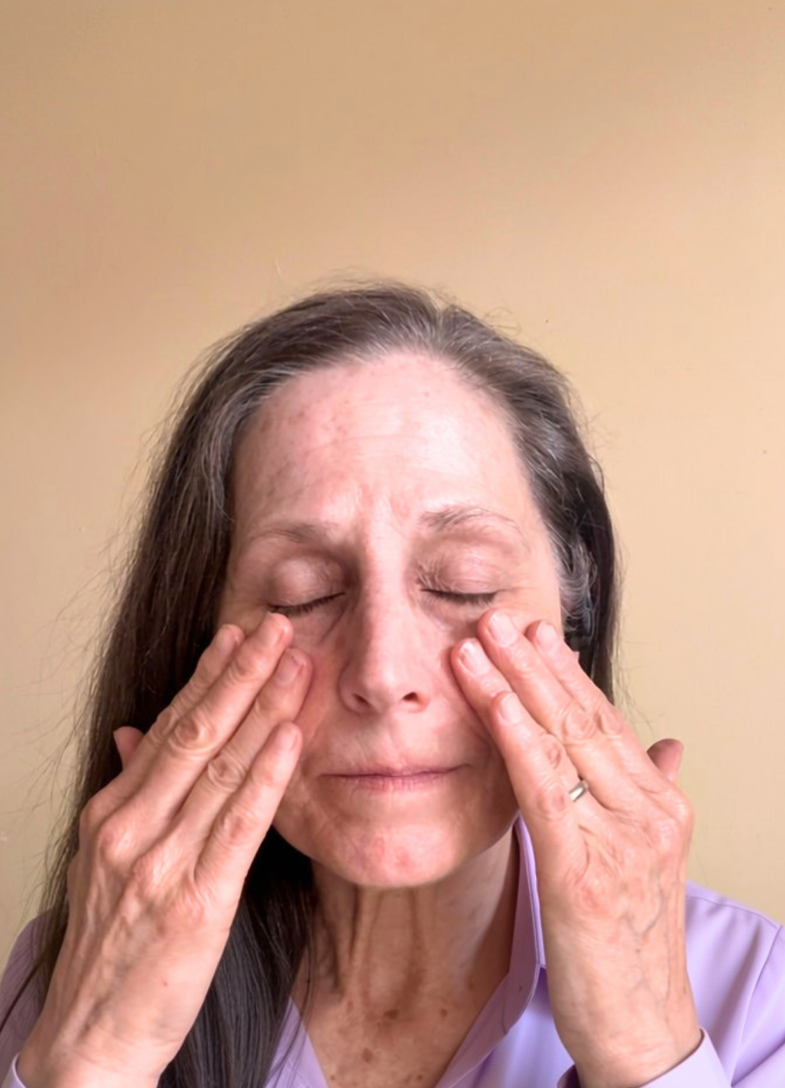 A woman with closed eyes and hands touching her face, shown against a beige background with a green banner at the top reading 'THE FANCIFUL FOX BOTANICAL HANDCRAFTED SKINCARE'.