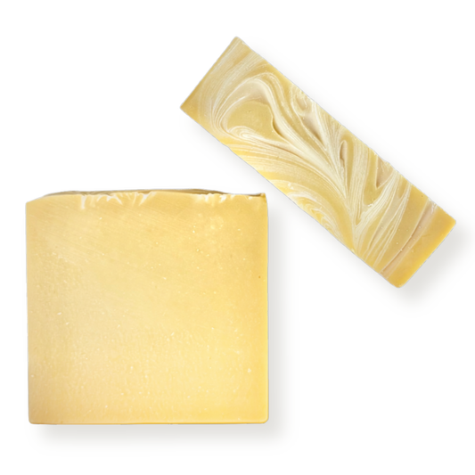 Two rectangular bars of handmade soap on a white background, one solid pale yellow and the other featuring a marbled swirl pattern of pale yellow and white.