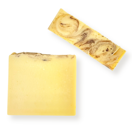 Two rectangular bars of handmade soap on a white background, one solid pale yellow and the other with a marbled swirl pattern of pale yellow, cream, and brown.
