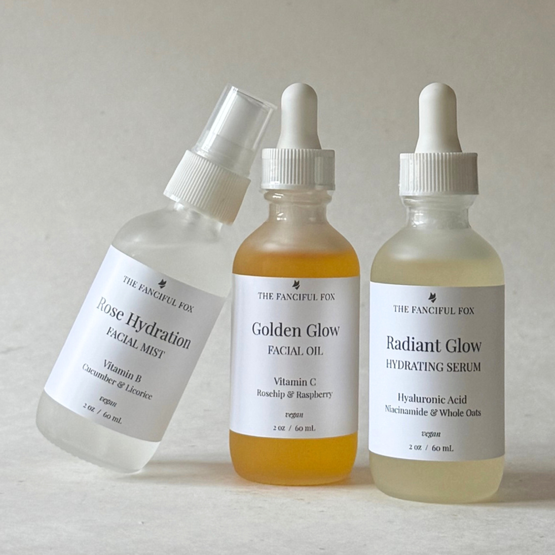 Three skincare bottles labeled 'Golden Glow Facial Oil', 'Radiant Glow Hydrating Serum', and 'Clear Hydration Facial Water' on a light surface.